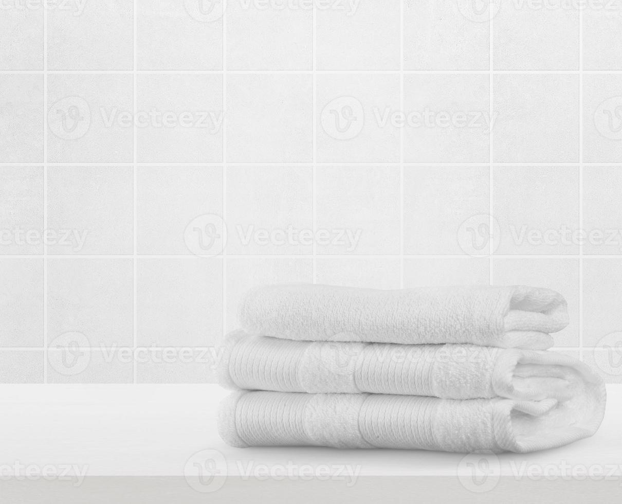 Stack of white clean towels on table in bathroom photo