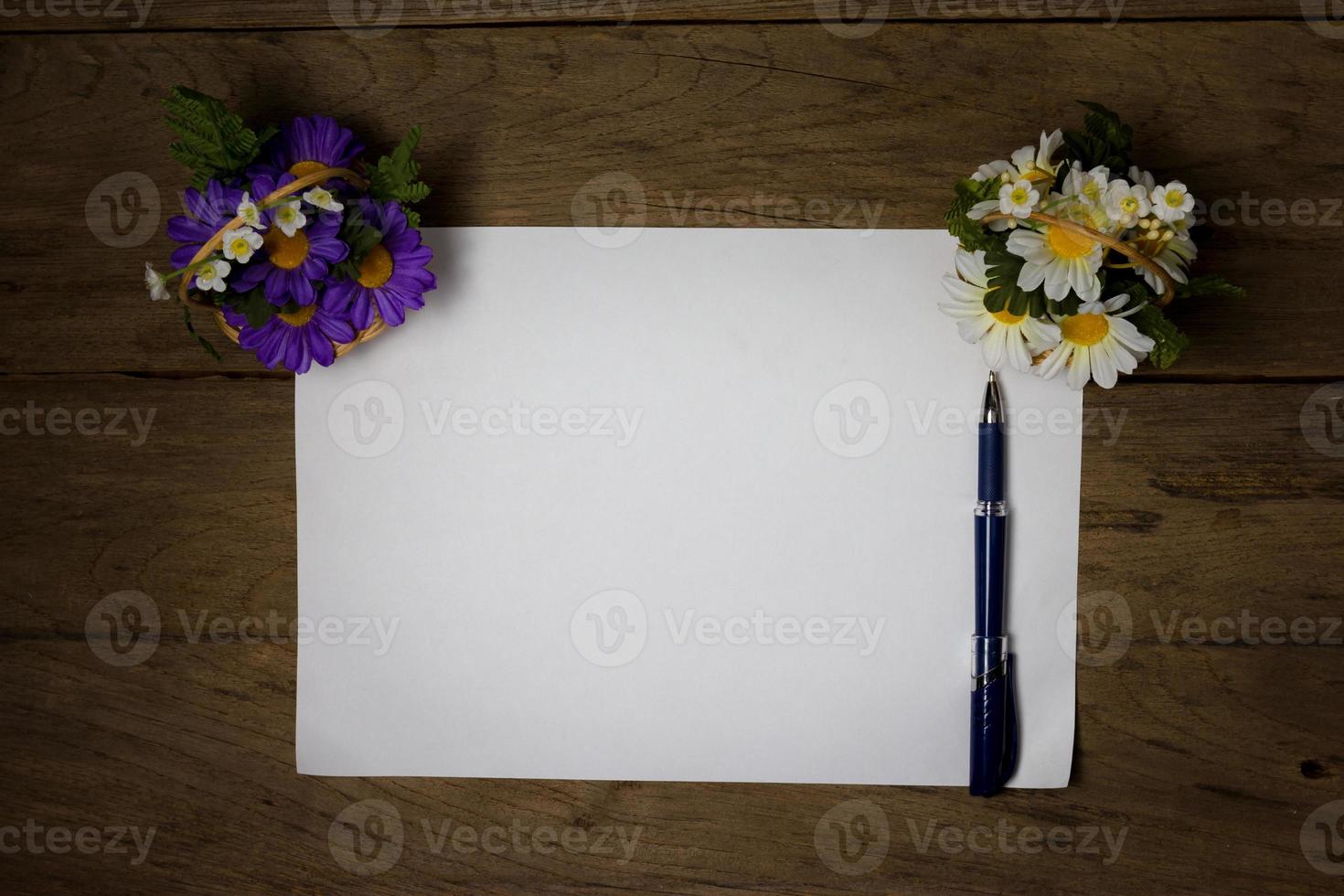 una hoja de papel con un bolígrafo en el escritorio de oficina de madera foto