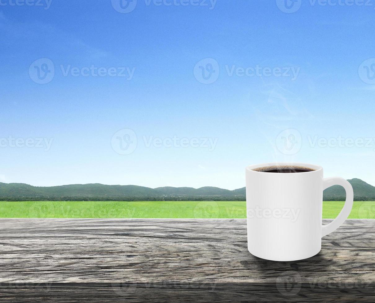 Coffee cup with smoke on wooden table terrace with a refreshing atmosphere in the morning, natural landscape photo