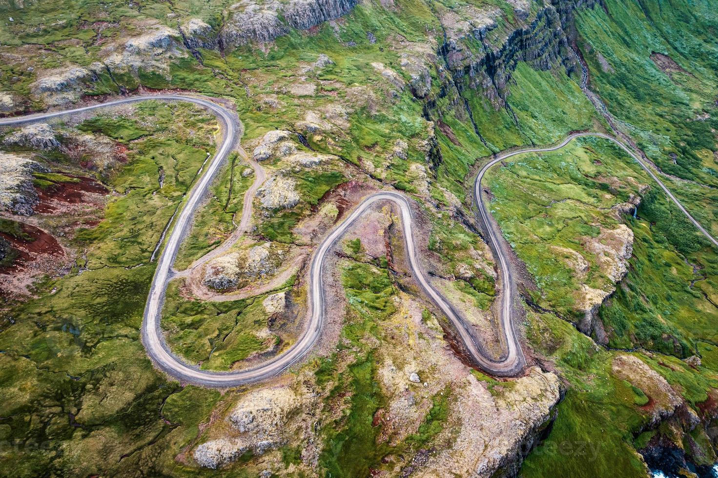 Winding gravel road through fjord of the valley in Icelandic highlands photo