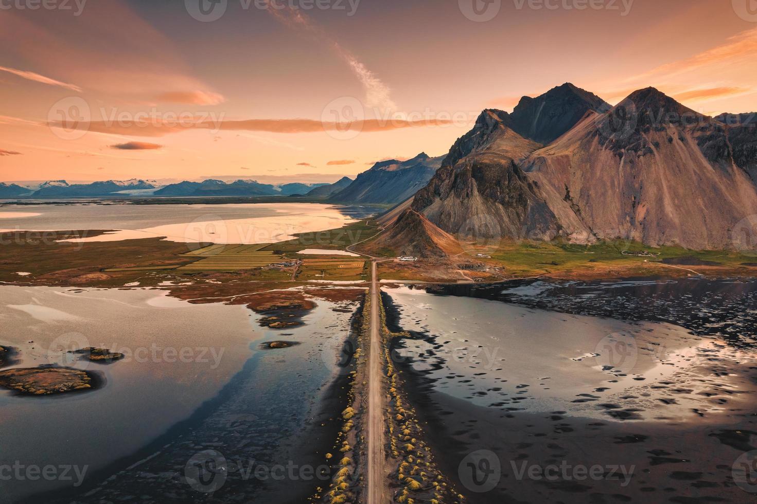 Beautiful sunrise over Vestrahorn mountain with road into the black sand beach in Atlantic ocean at Stokksnes on the southeastern at Iceland photo