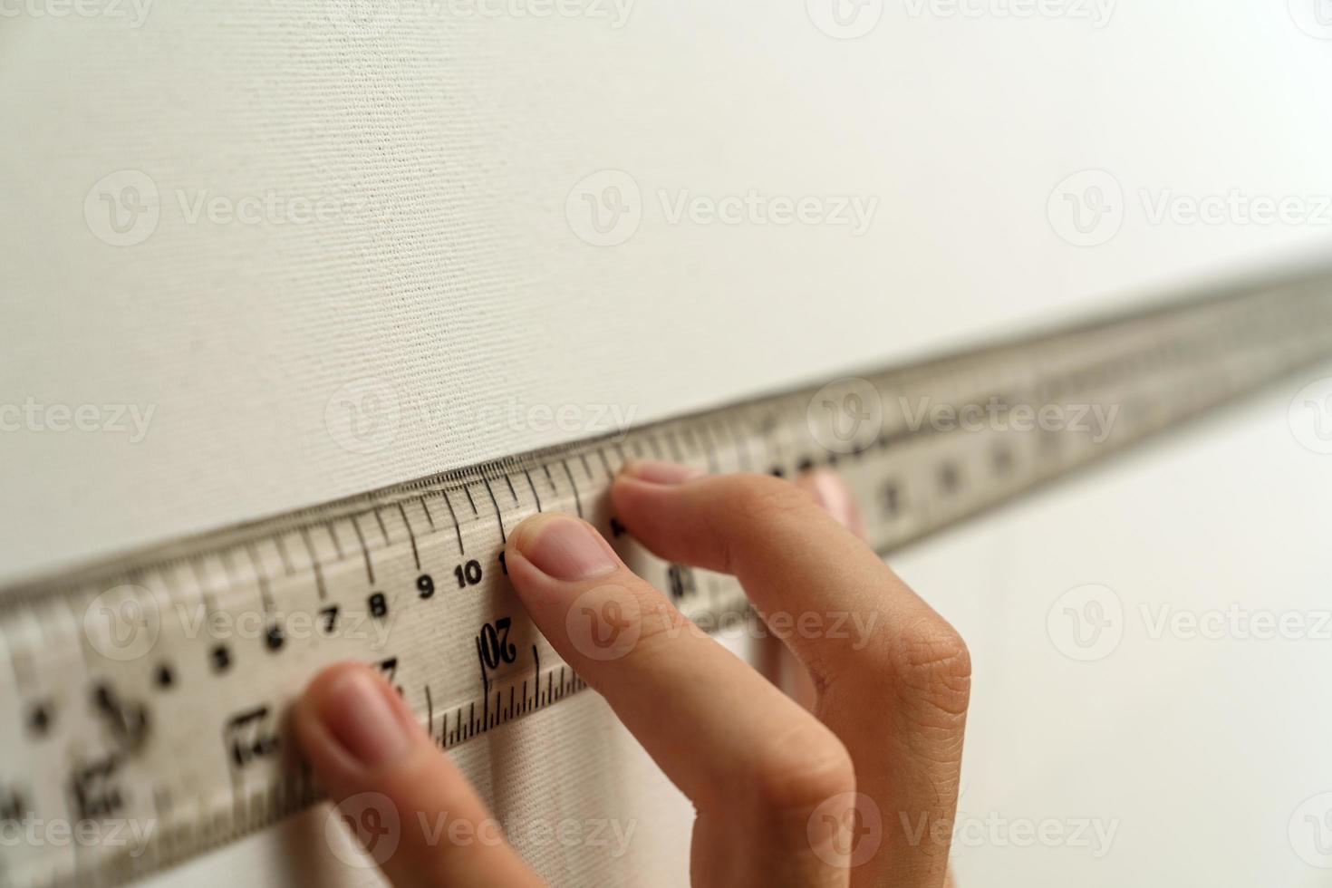 hand holding ruler with canvas background photo