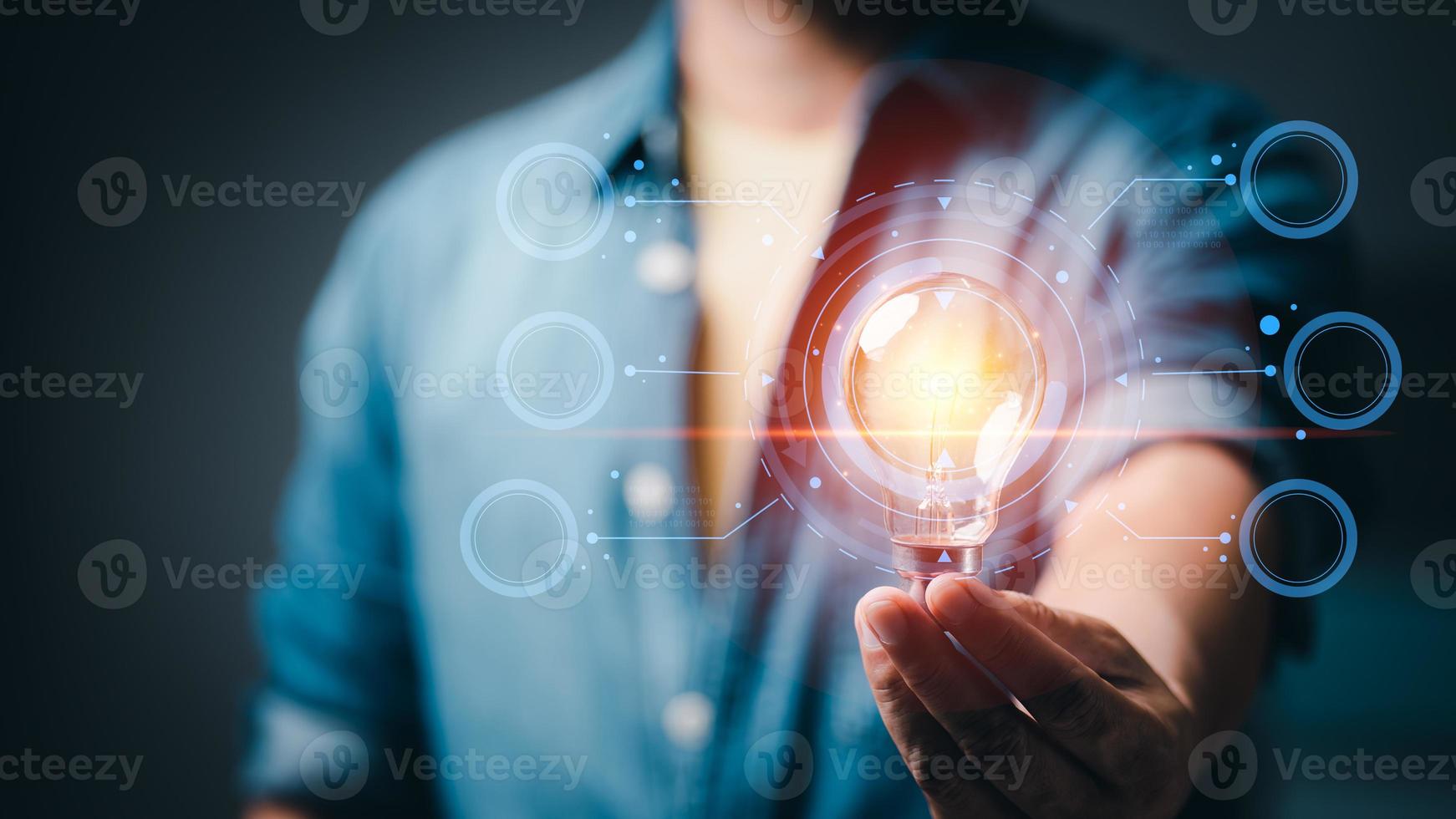 Businessman holding a light bulb showing ideas to brainstorm, imagine, inspire, innovative technology concepts through thinking, education, creativity. photo