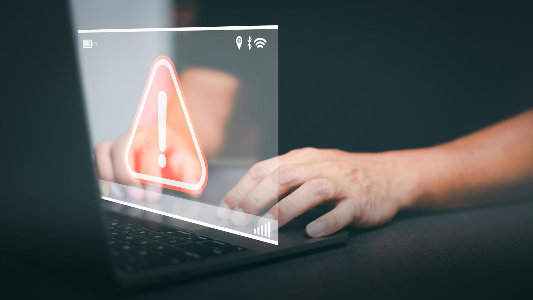 Businessman working on laptop computer, exclamation mark, alarm, warning, computer virus detected, danger warning concept or information error that should be urgently fixed and repaired. photo