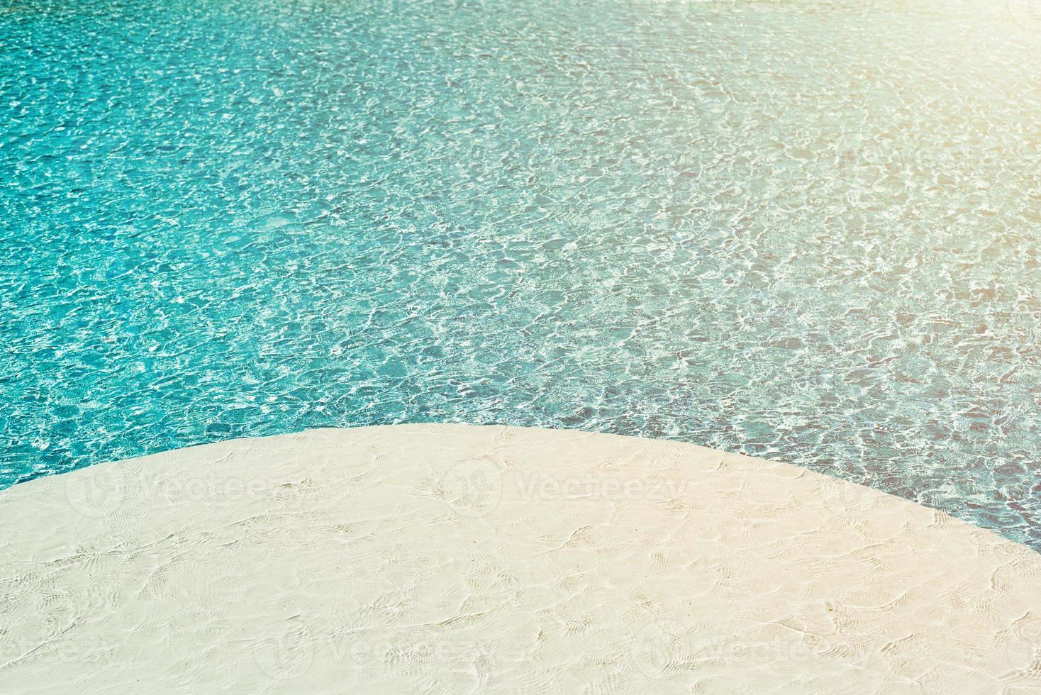 fondo de agua en la piscina azul, superficie de agua con un reflejo del sol foto