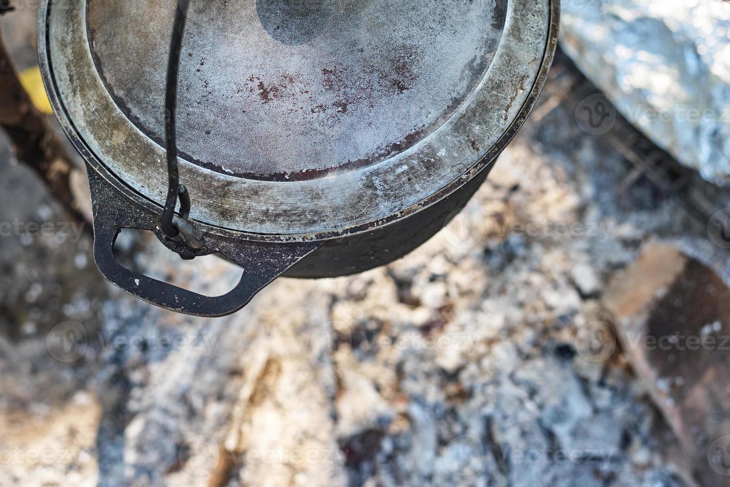 Close up of boiling pot at rhe campfire on picnic. Hike cooking concept photo