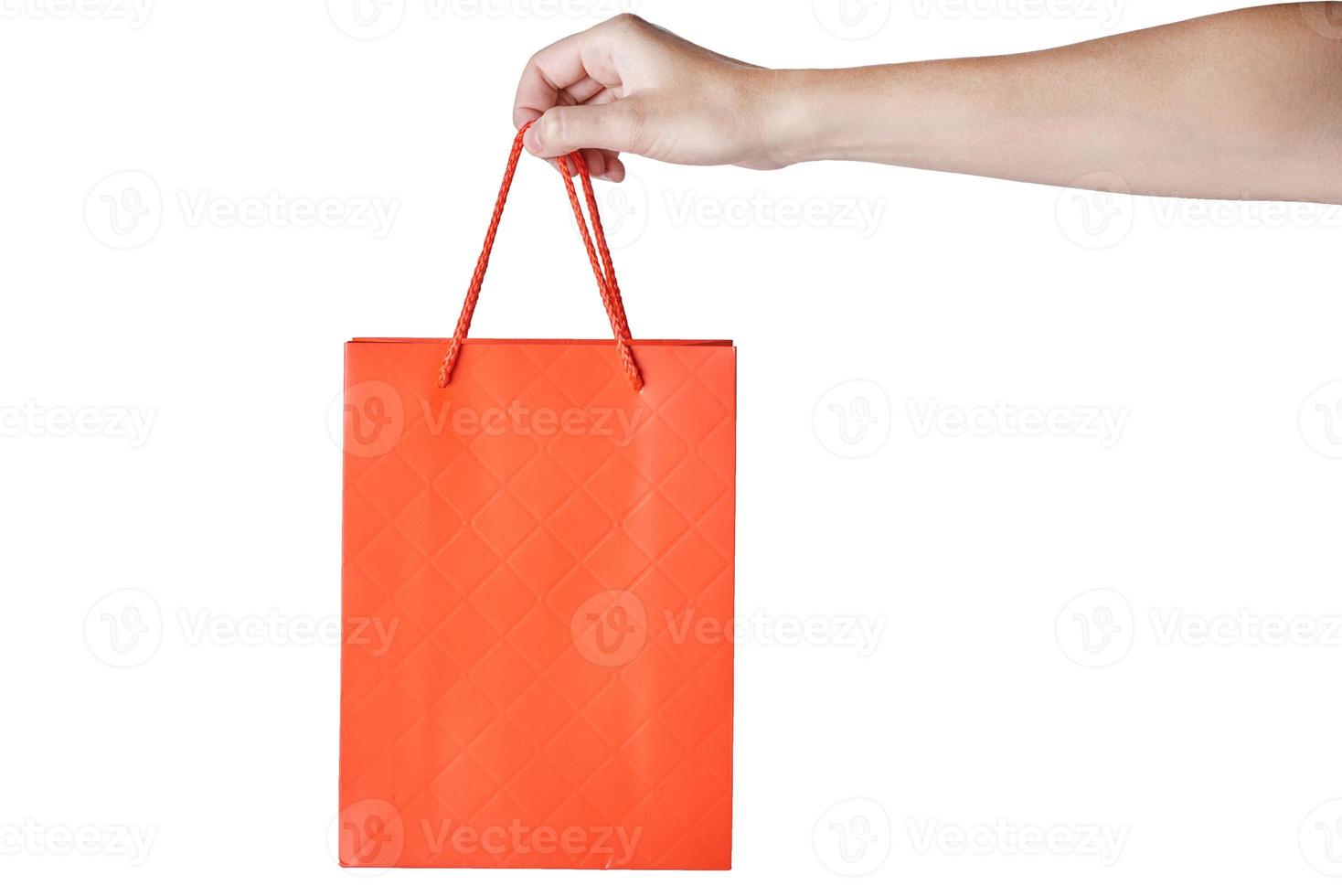 mano de mujer sostenga la bolsa de compras de papel artesanal en blanco vacía roja aislada sobre fondo blanco. maqueta de plantilla de embalaje foto