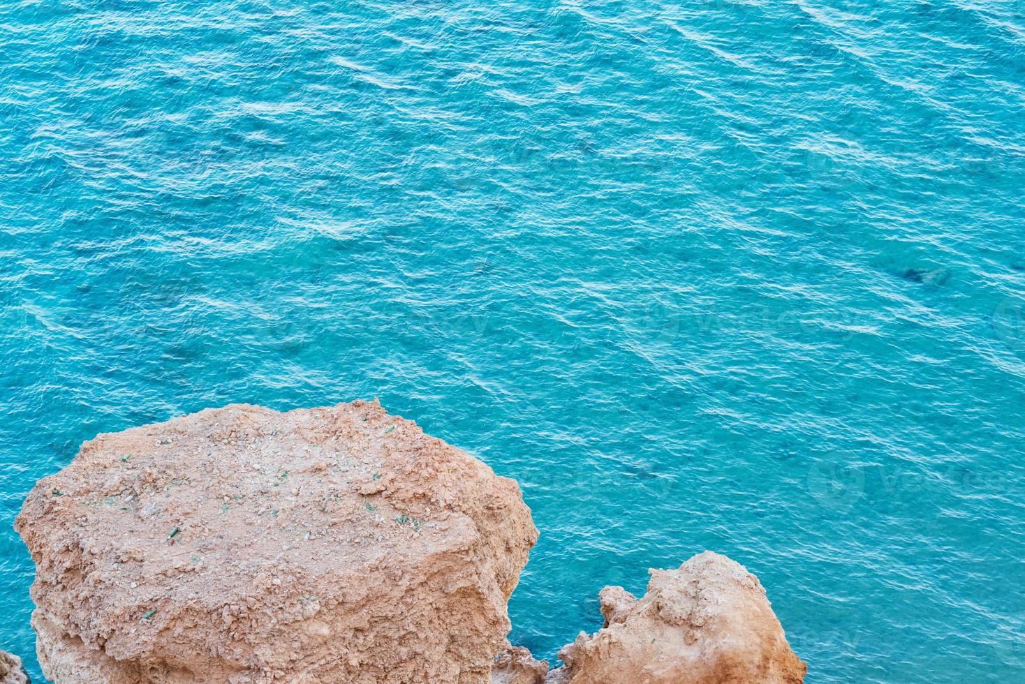 View from rock cliff on turquoise water of sea photo