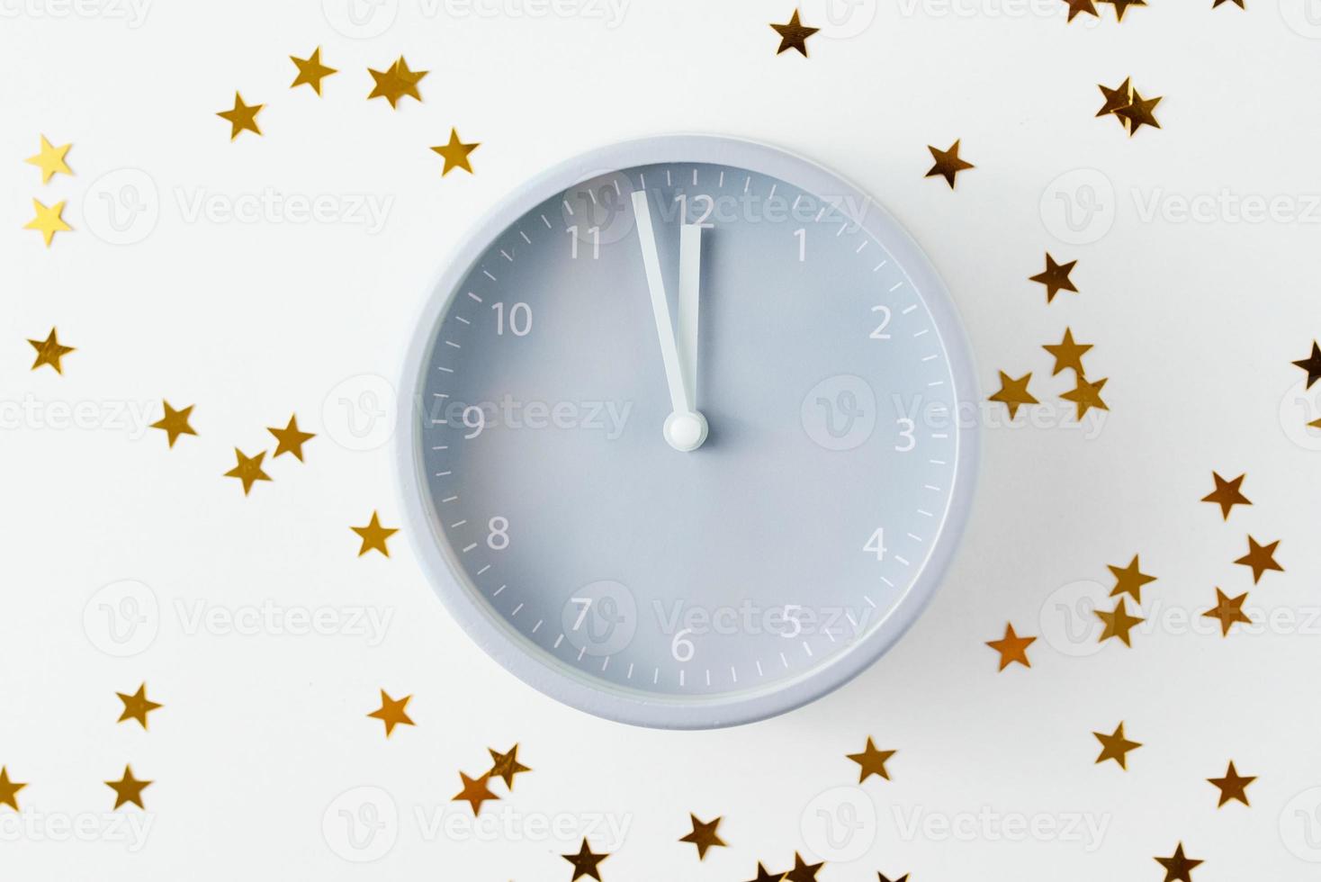 Christmas background with alarm clock and stars confetti on white background photo