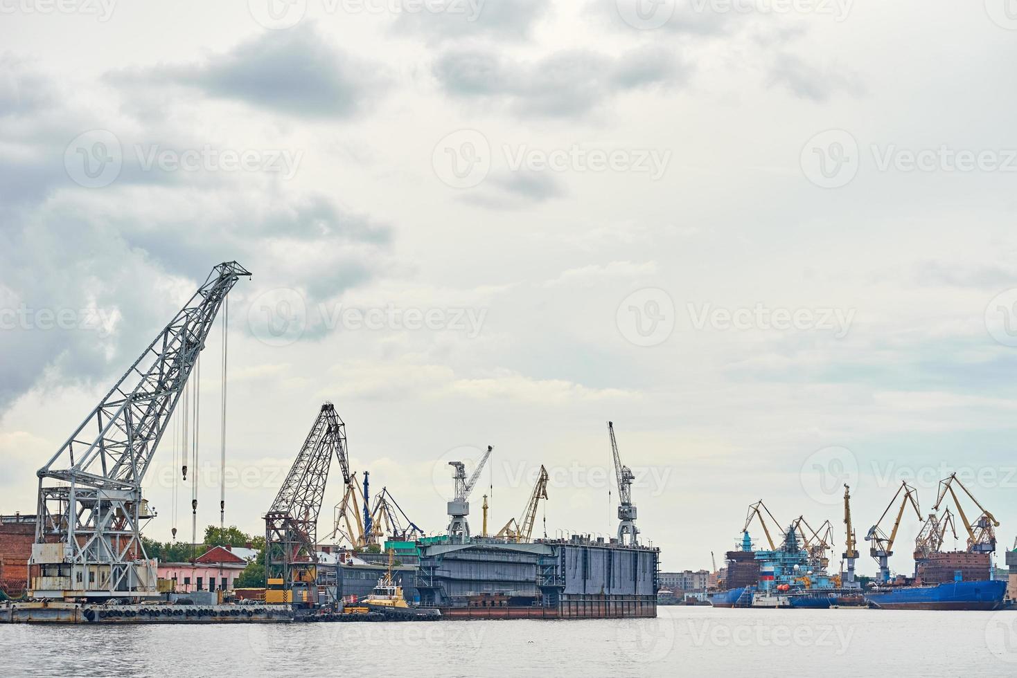 working crane bridge in shipyard and cargo ships in a port photo
