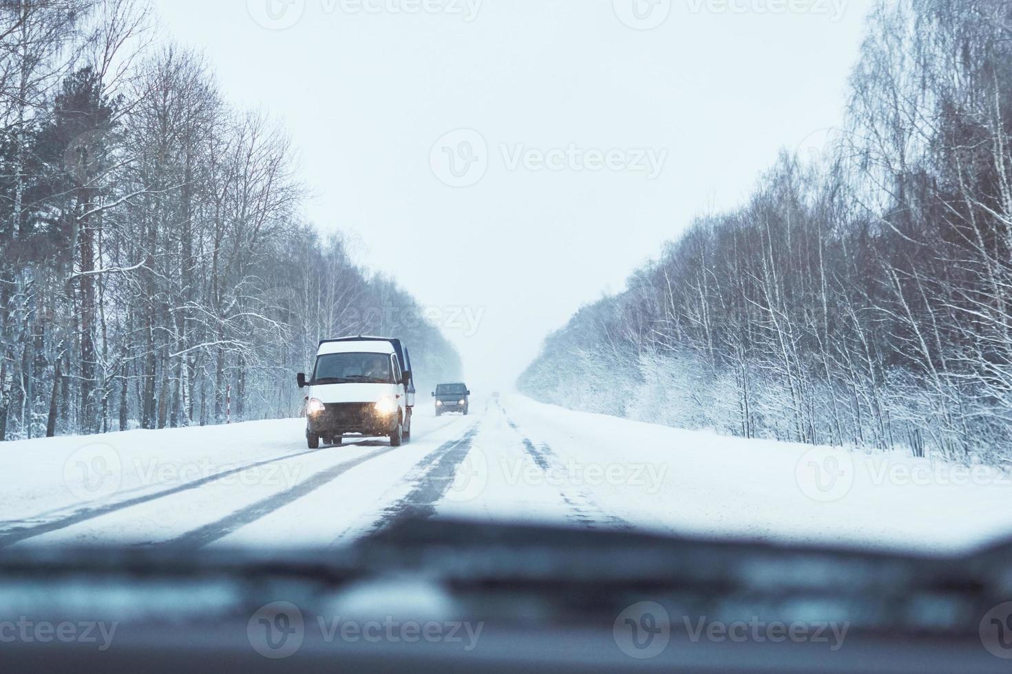 Back view of car on snowy winter road photo