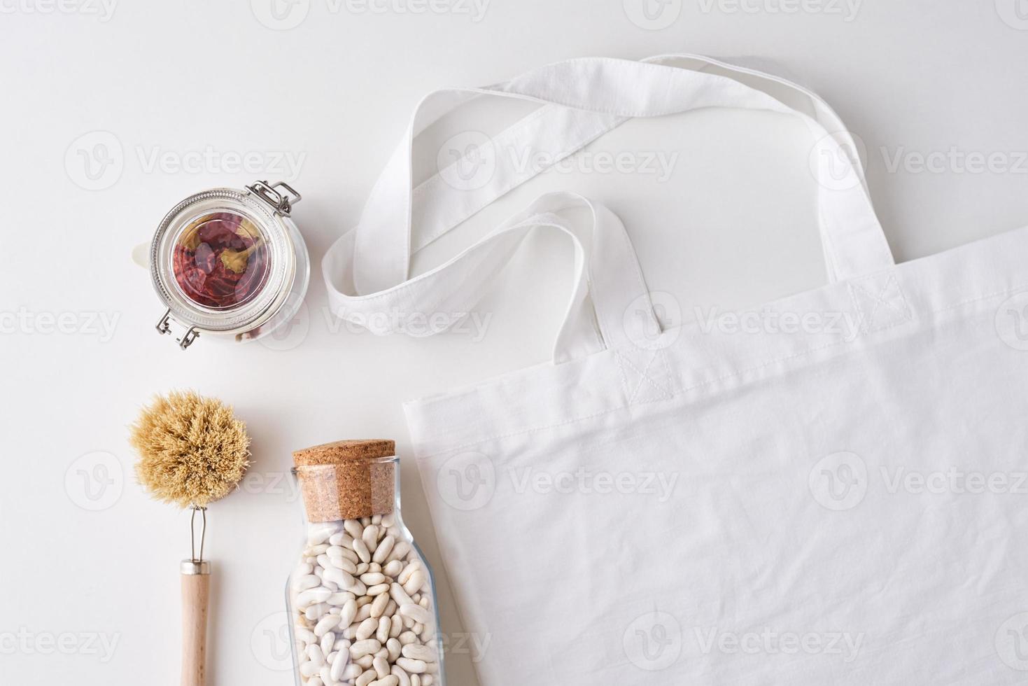 Glass jar, wooden brush and shopping bag on a white background. photo