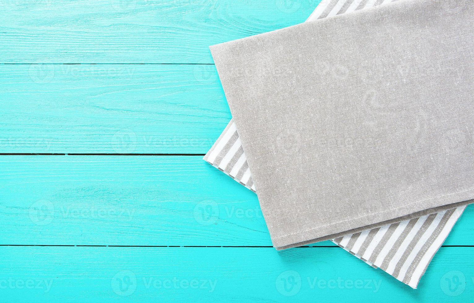Gray and white striped tablecloth on blue wooden kitchen. Top view and copy space. Mock up photo