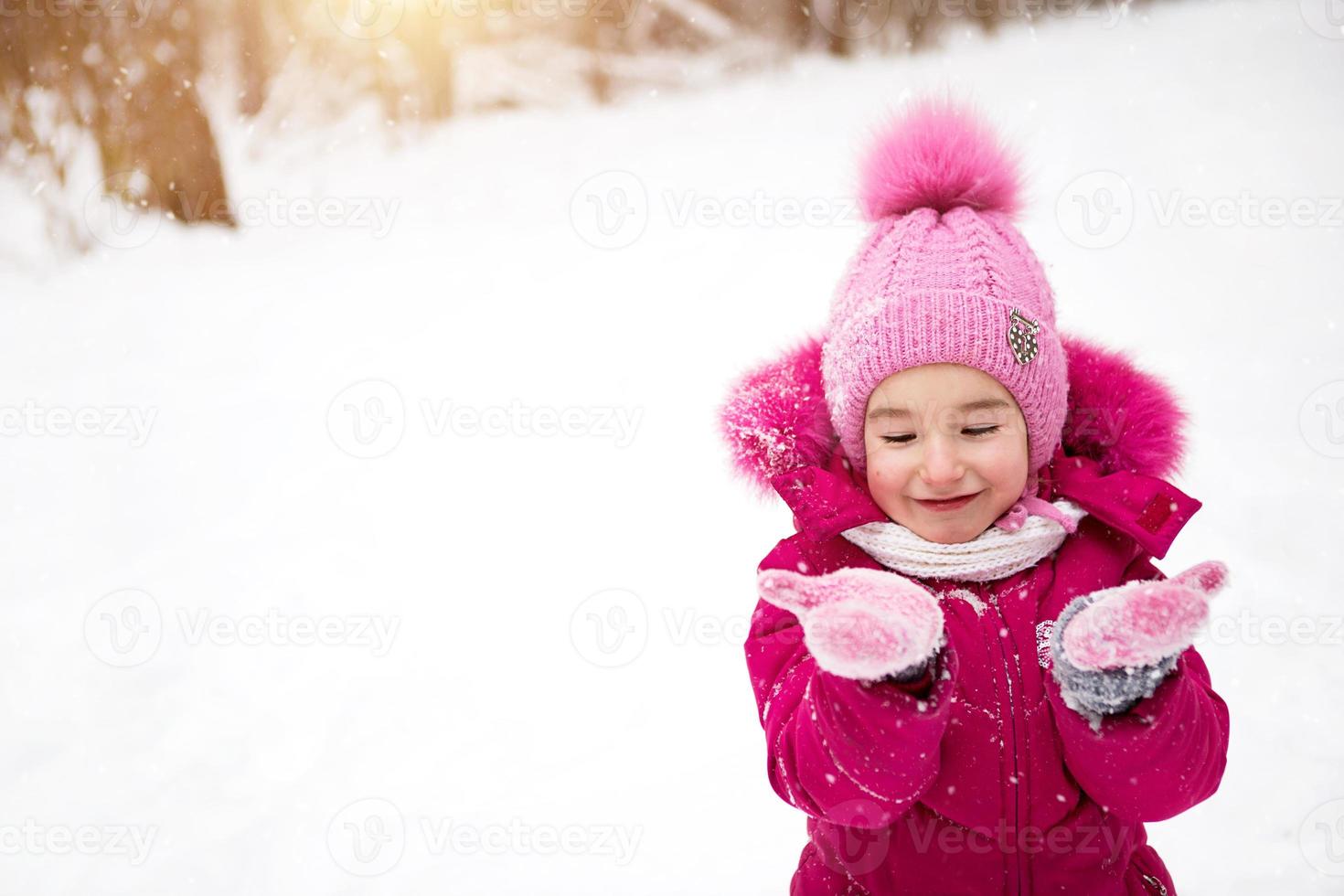 Niña del niño caucásico en ropa de invierno caliente y orejeras