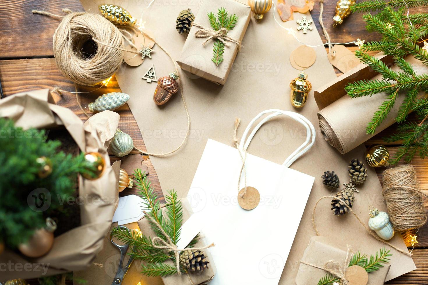 Gift Package for Christmas and new year in eco-friendly materials kraft paper, live fir branches, cones, twine. Tags with mock up, natural decor, hand made, DIY. Copy space. Flatly, background photo