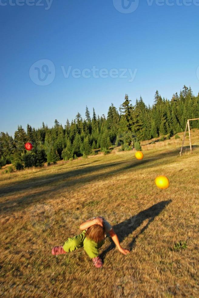 happy girl throwing apple outside photo