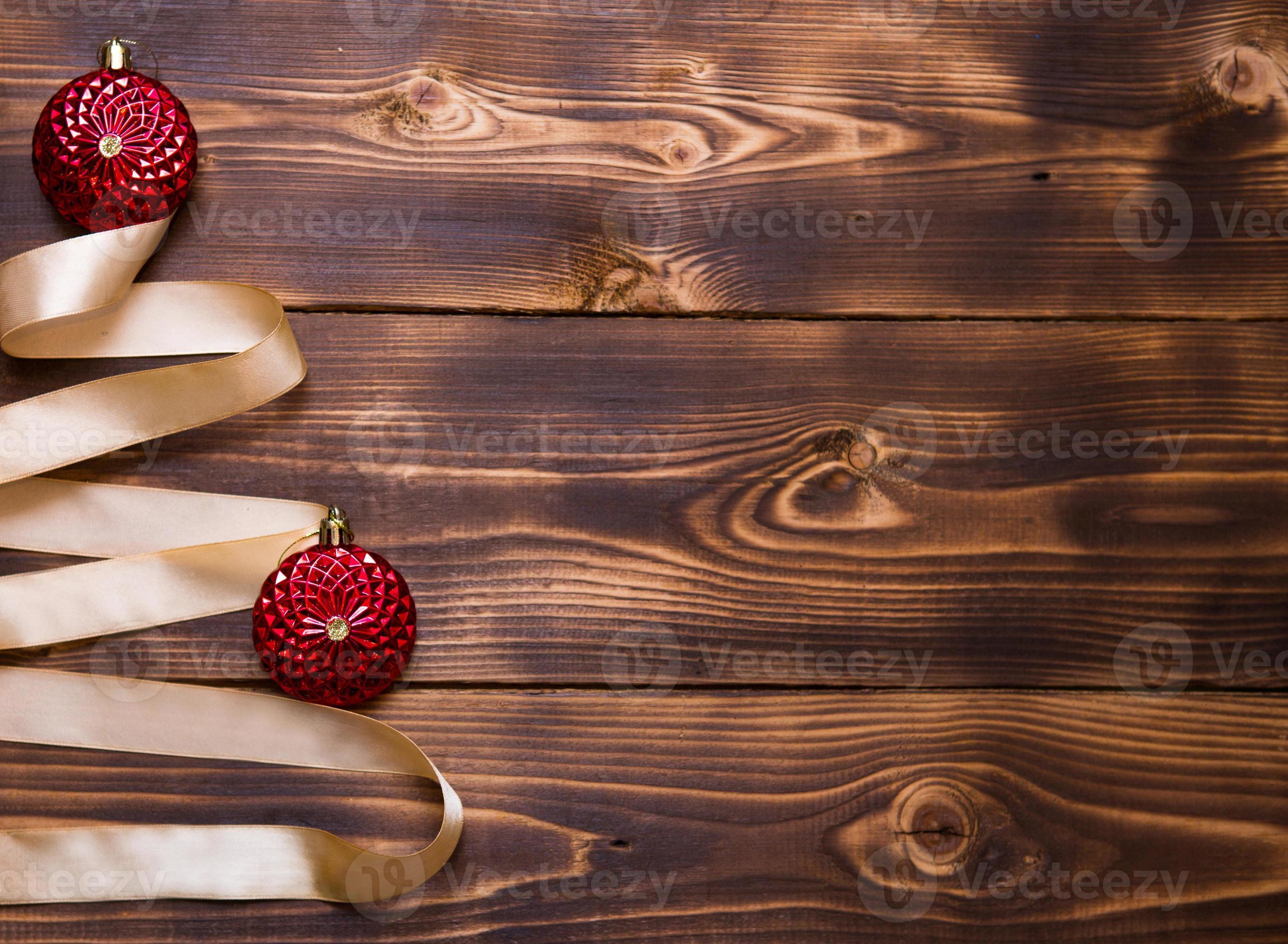 A Christmas tree made of gold ribbon decorated with red round toys on a