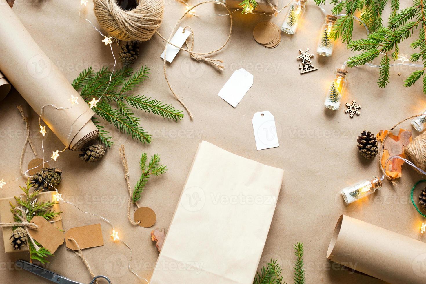 Gift Package for Christmas and new year in eco-friendly materials kraft paper, live fir branches, cones, twine. Tags with mock up, natural decor, hand made, DIY. Copy space. Flatly, background photo