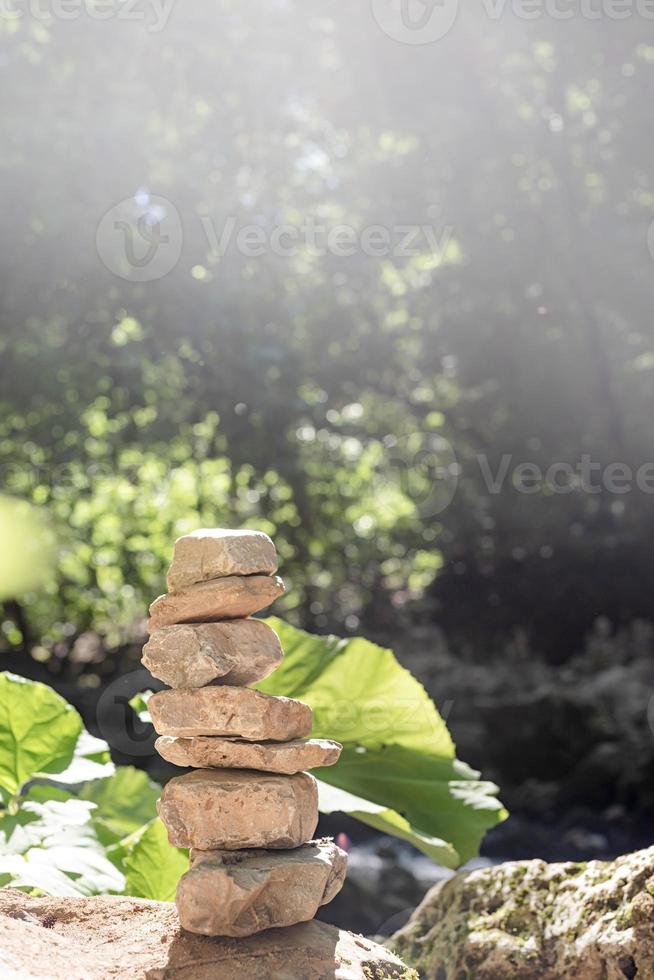 A stack of zen rocks are in the forest with trees in the background photo