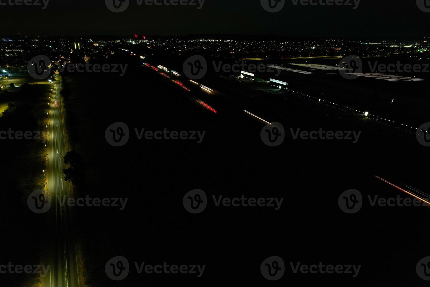 Night Aerial View of British Motorways with illuminated Roads and Traffic. Highways footage taken with drone's camera over Milton Keynes and motorways of England at Dark Night photo