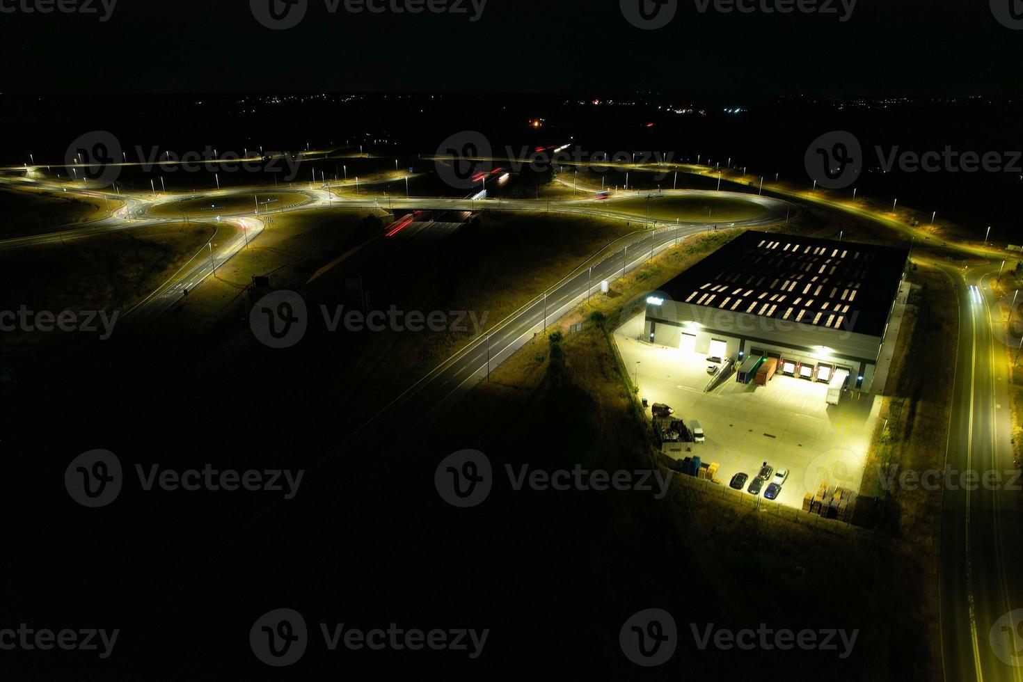 Night Aerial View of British Motorways with illuminated Roads and Traffic. Highways footage taken with drone's camera over Milton Keynes and motorways of England at Dark Night photo