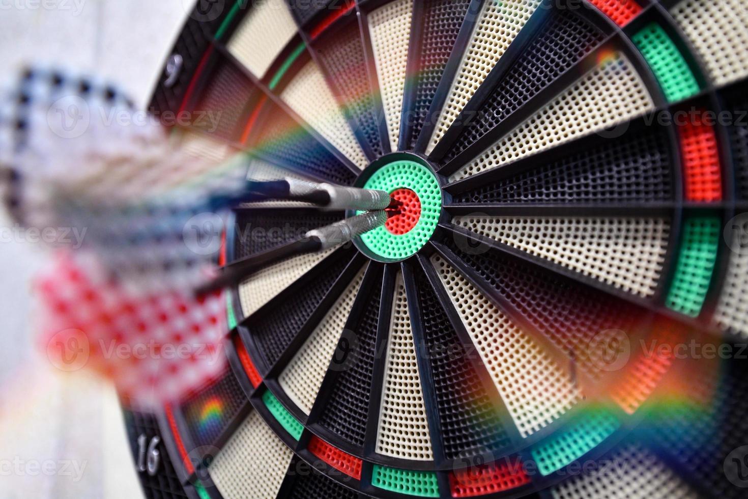 Darts arrow hitting in the target center photo