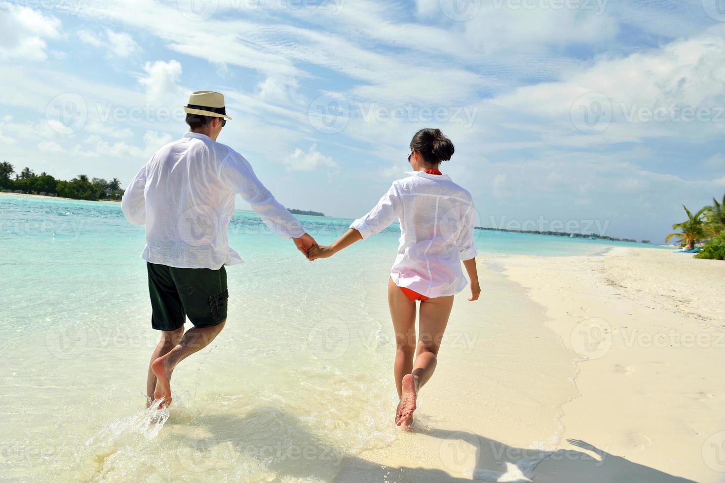 happy young couple have fun on beach photo