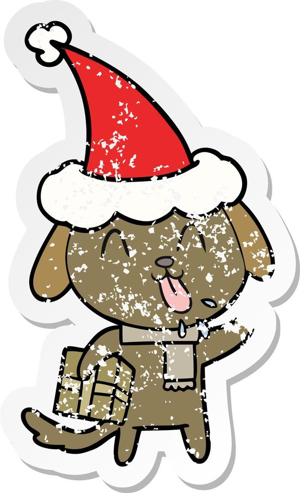 cute distressed sticker cartoon of a dog with christmas present wearing santa hat vector