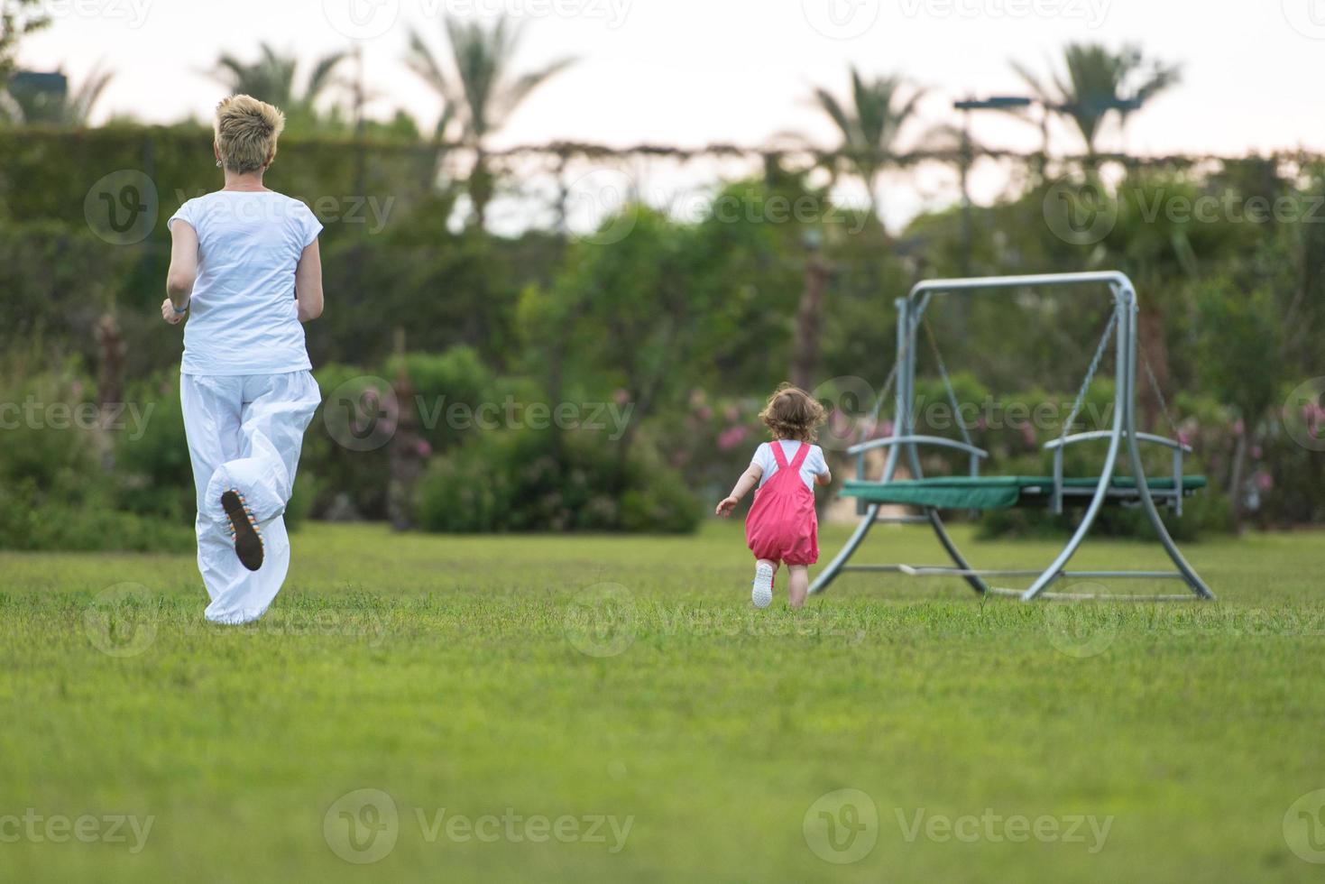 mother and little daughter playing at backyard photo