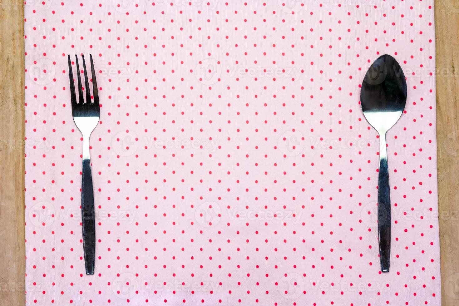 doily with spoon and fork on wooden background. photo