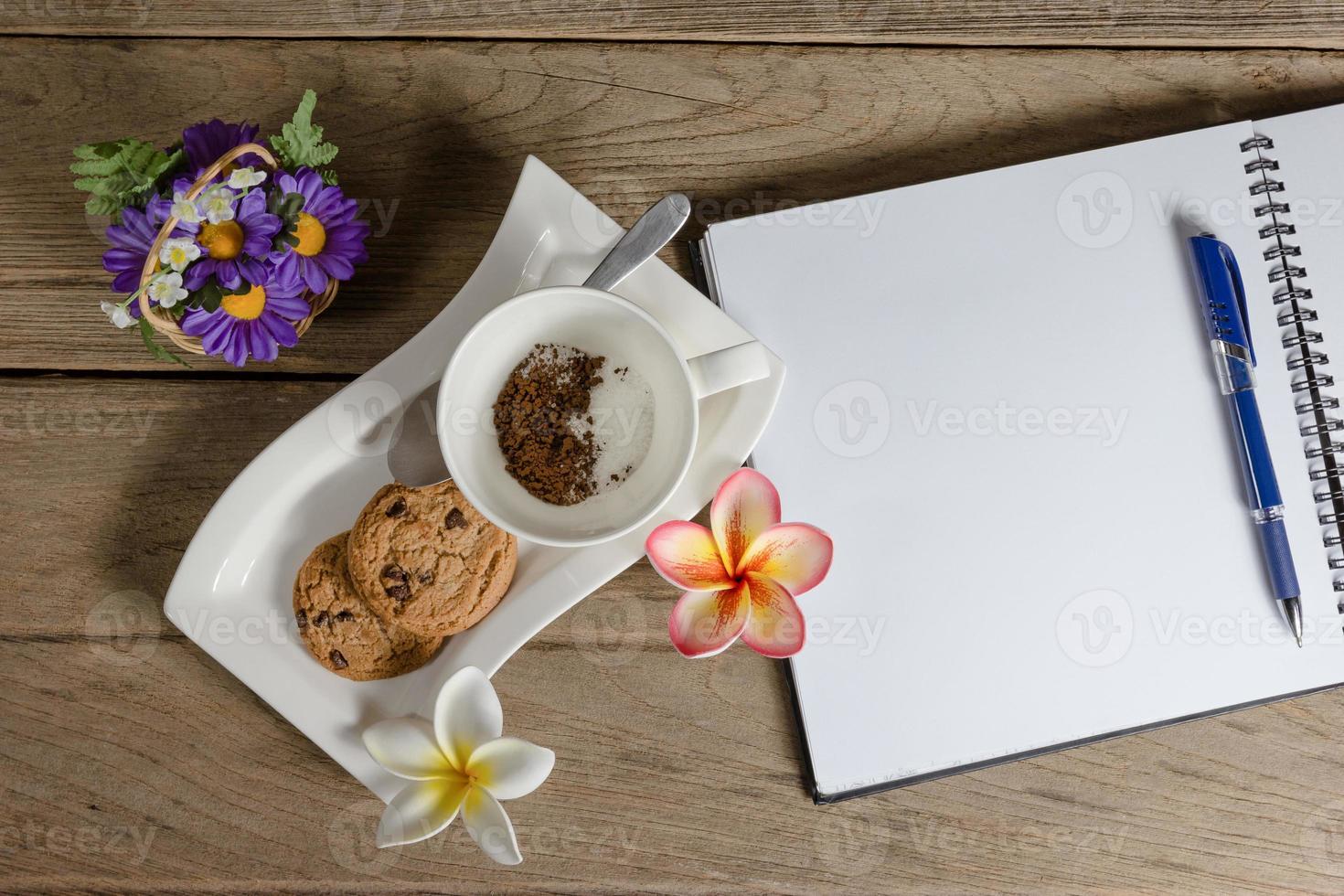 coffee powder and sugar in cup with cookies,open notebook. photo