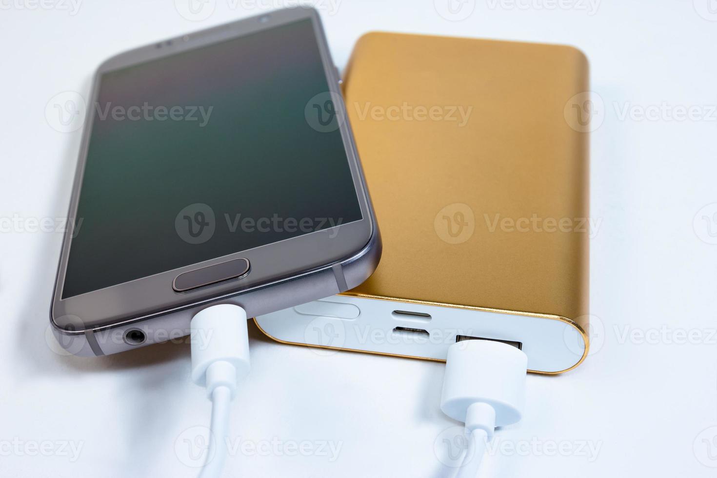 Golden powerbank with smart phone on background photo