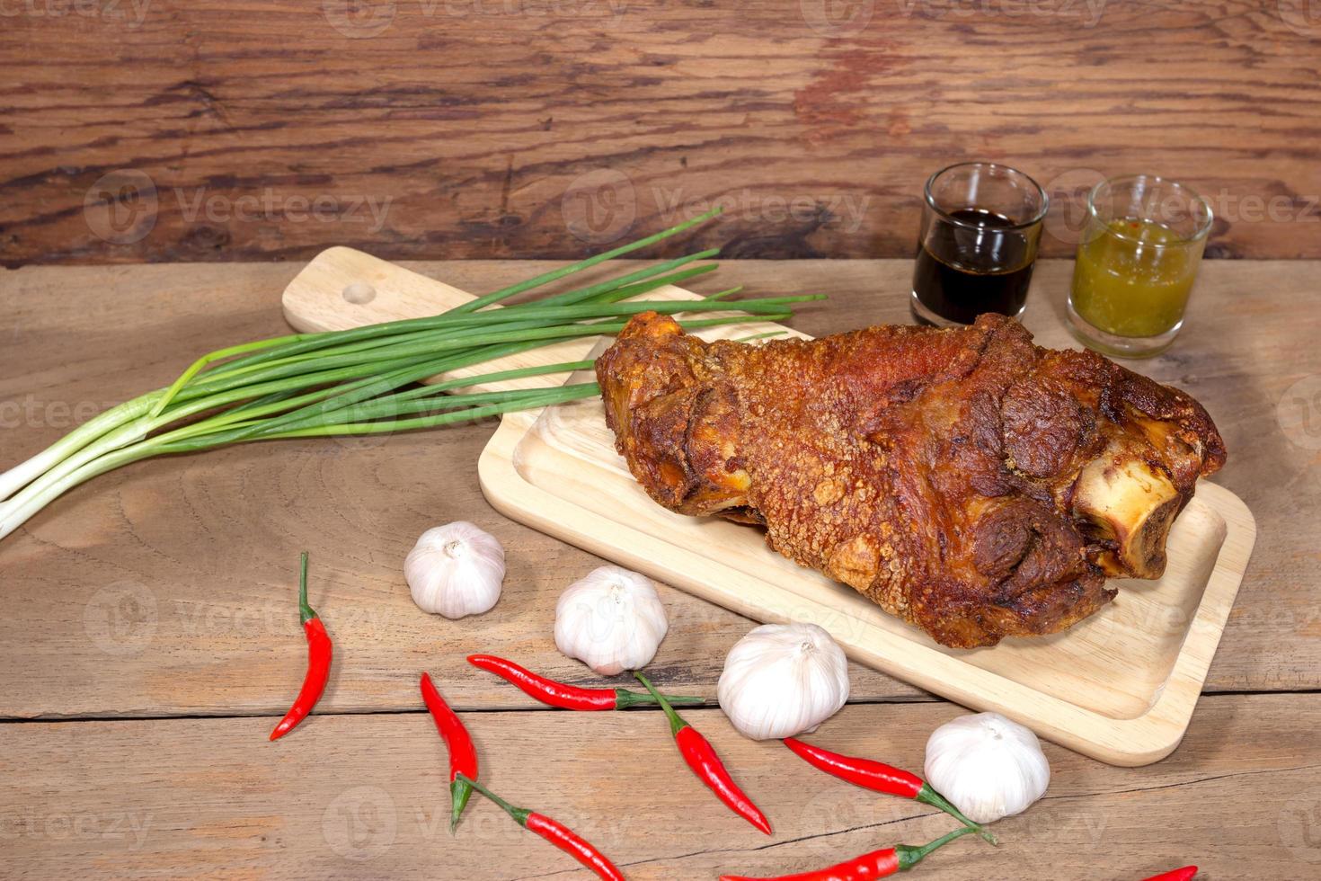 fried pork leg cooked on chopping block photo