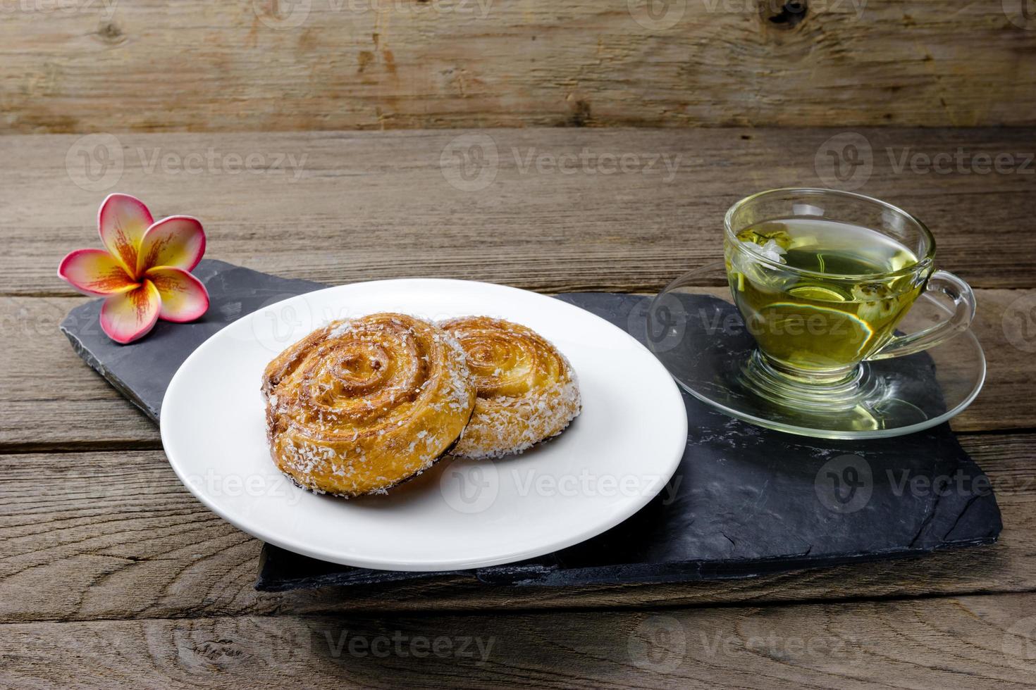 Cinnamon rolls with Chrysanthemum tea on wood background photo