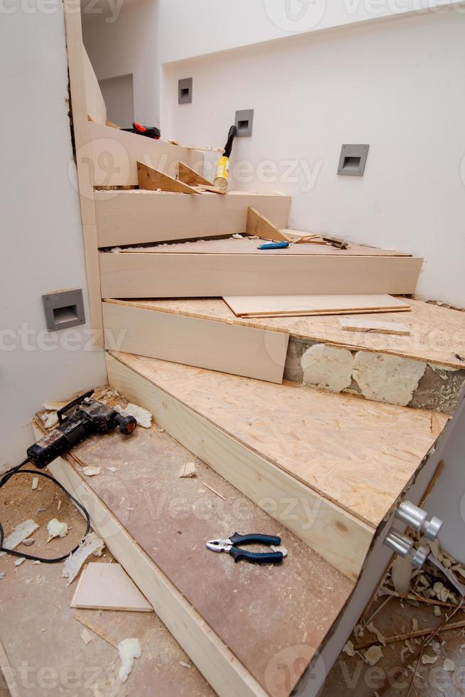 work in progress on stylish interior with wooden stairs photo