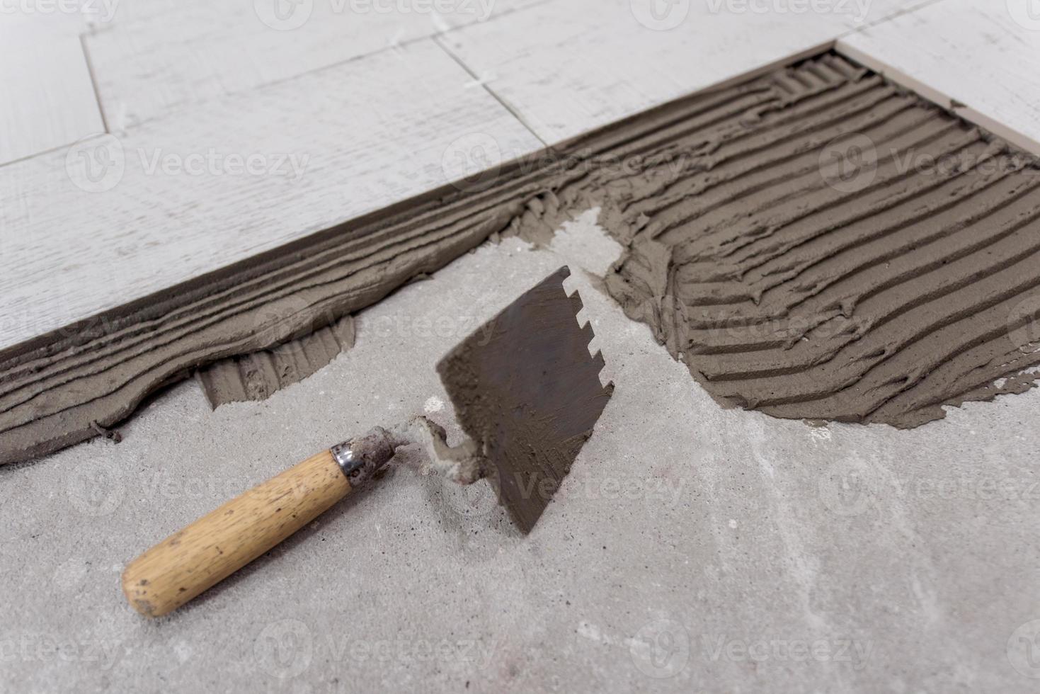 Ceramic wood effect tiles and tools for tiler on the floor photo