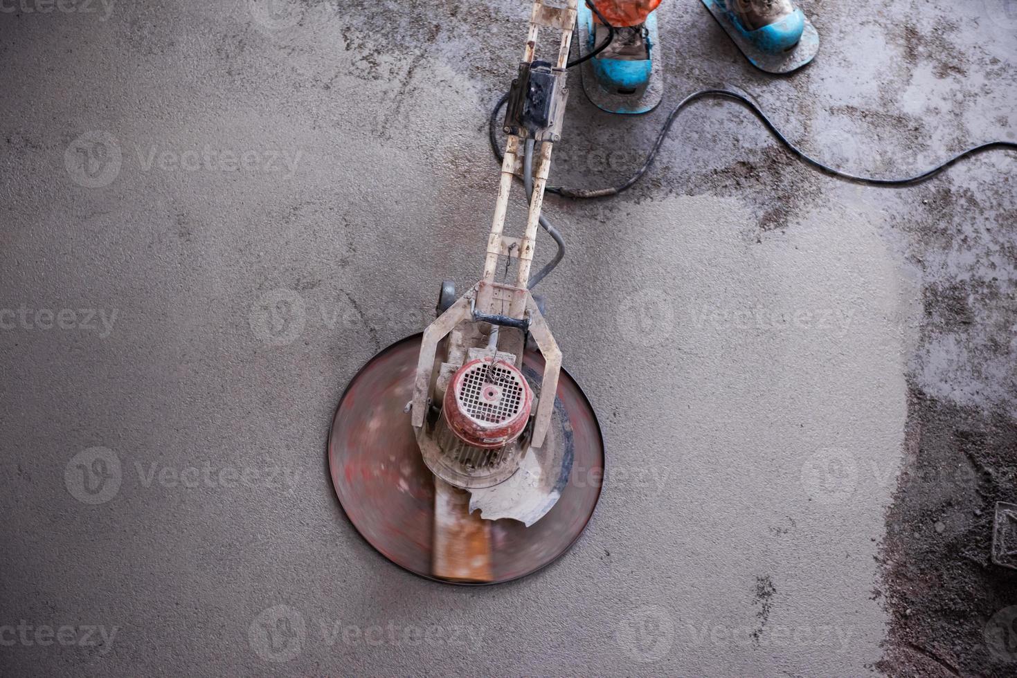 worker performing and polishing sand and cement screed floor photo