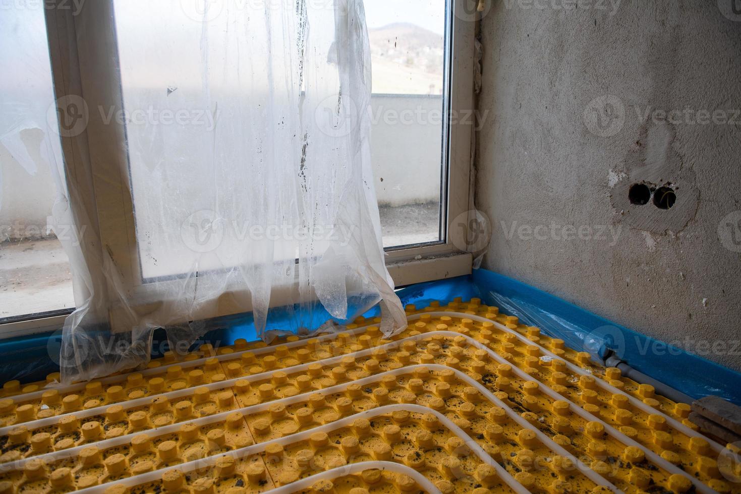 yellow underfloor heating installation with white pipes photo