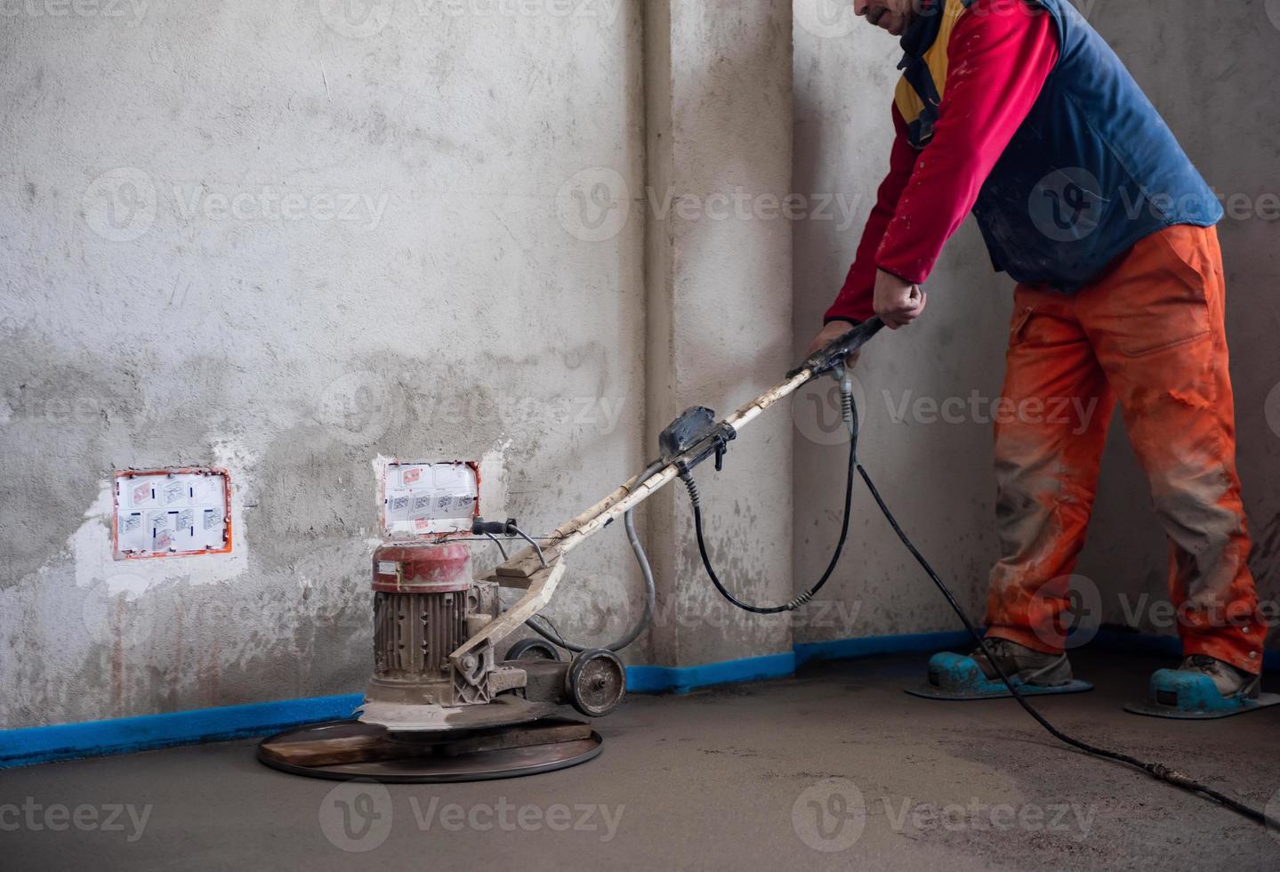 worker performing and polishing sand and cement screed floor photo