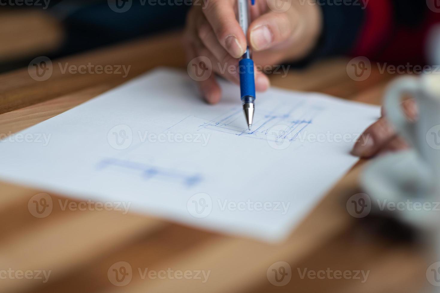 The hand of the designer with a pen sketching his idea photo