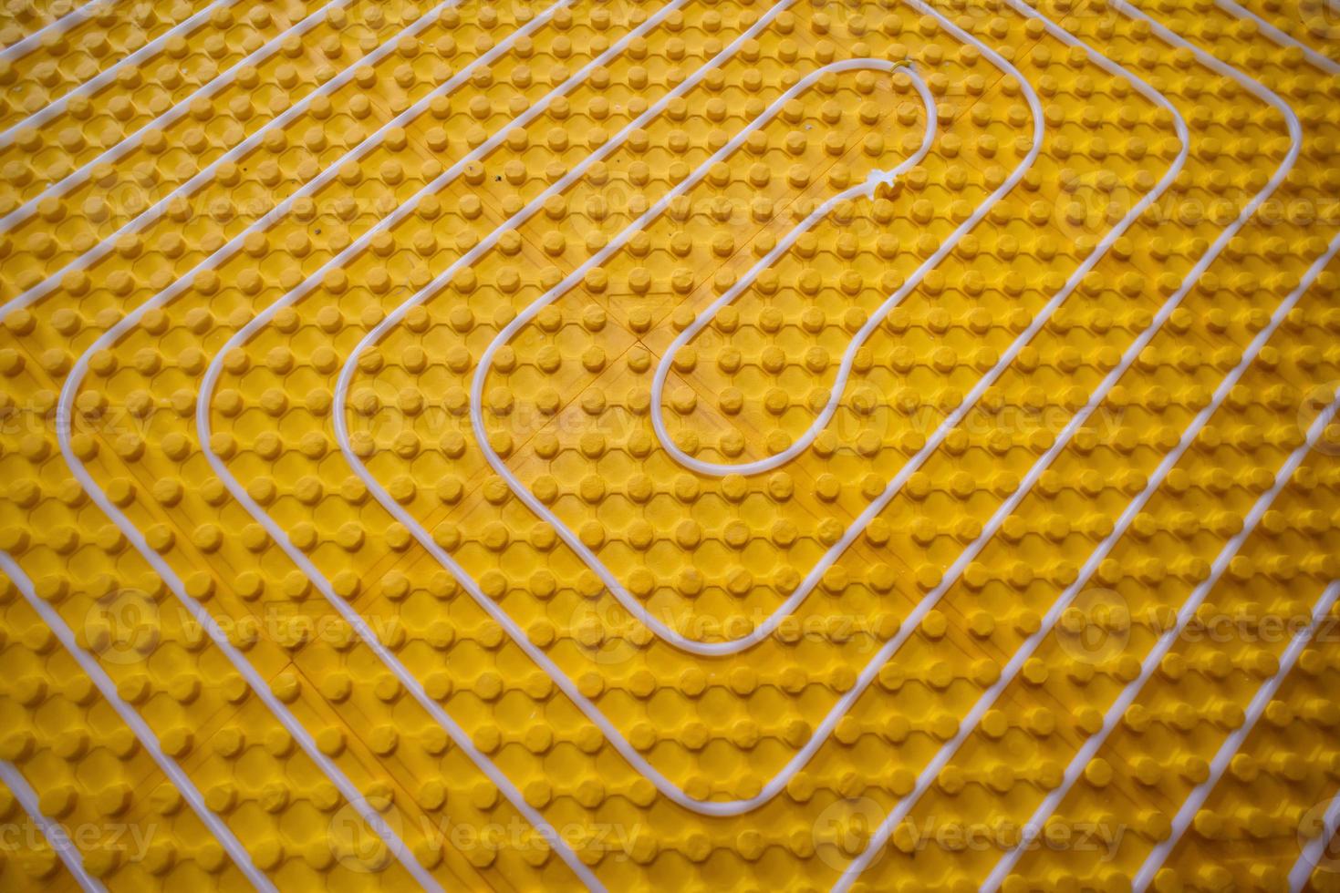 yellow underfloor heating installation with white pipes photo