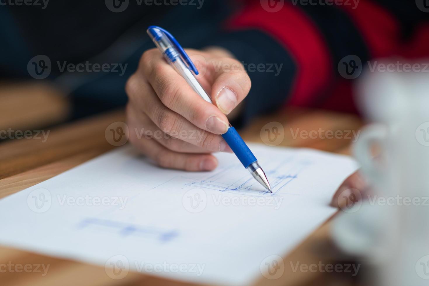 The hand of the designer with a pen sketching his idea photo