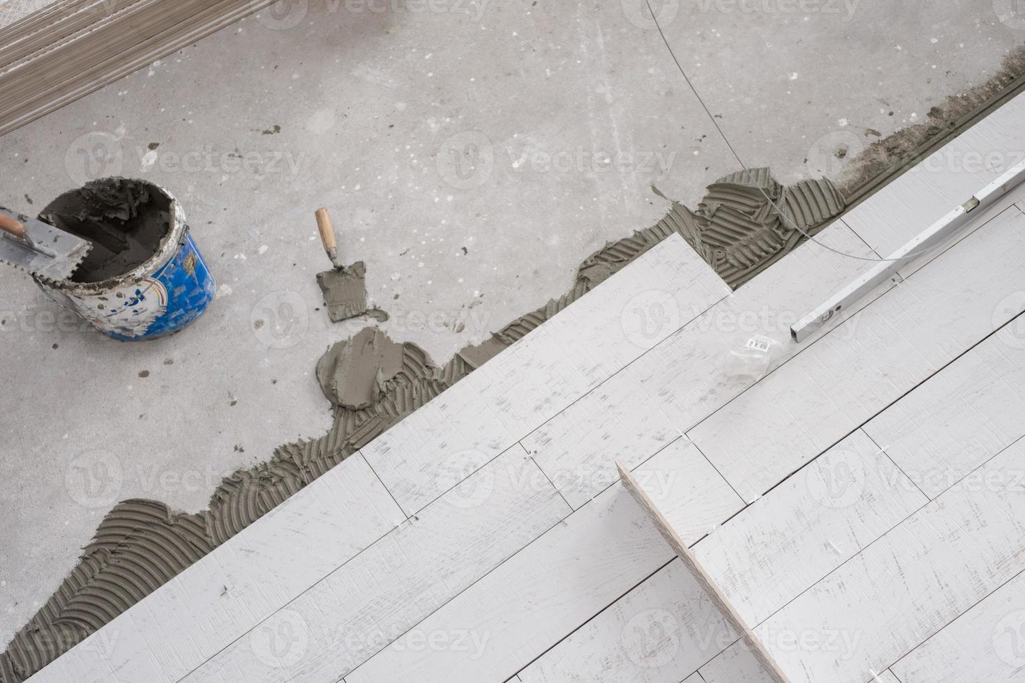 Ceramic wood effect tiles and tools for tiler on the floor photo