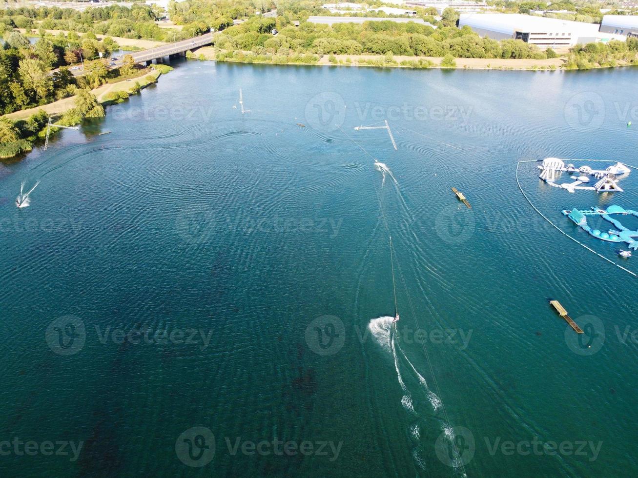Beautiful Aerial Drone's Camera  Footage of Willen Lake and Park which is located at Milton Keynes, England. People are Enjoying at Lake on a Hot Sunny Day of Summer photo