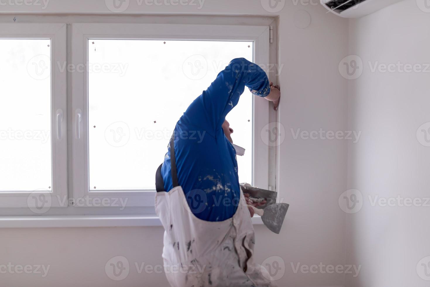 trabajador de la construcción enyesado en paredes de yeso foto