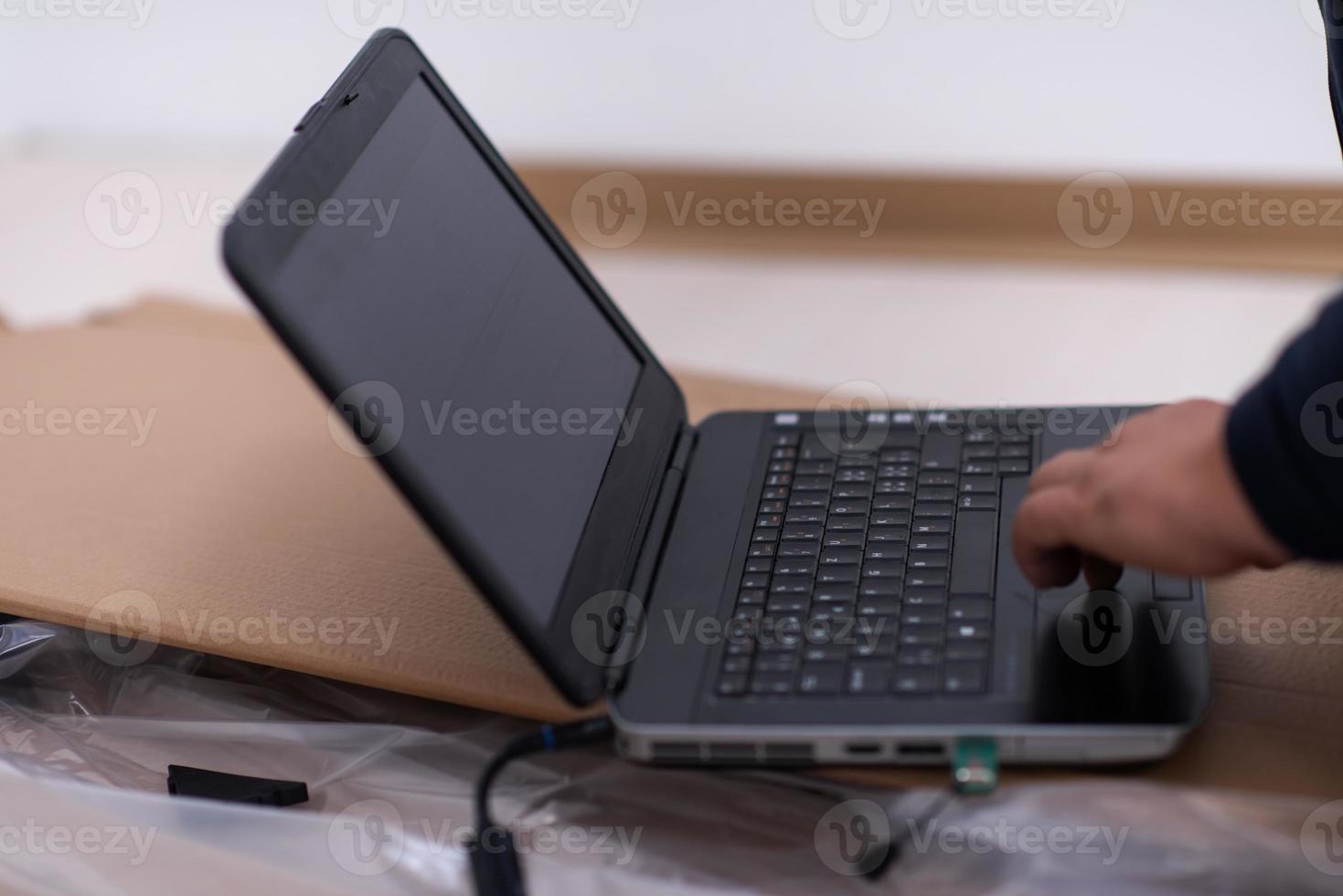 man using laptop while lying on cardboard box photo
