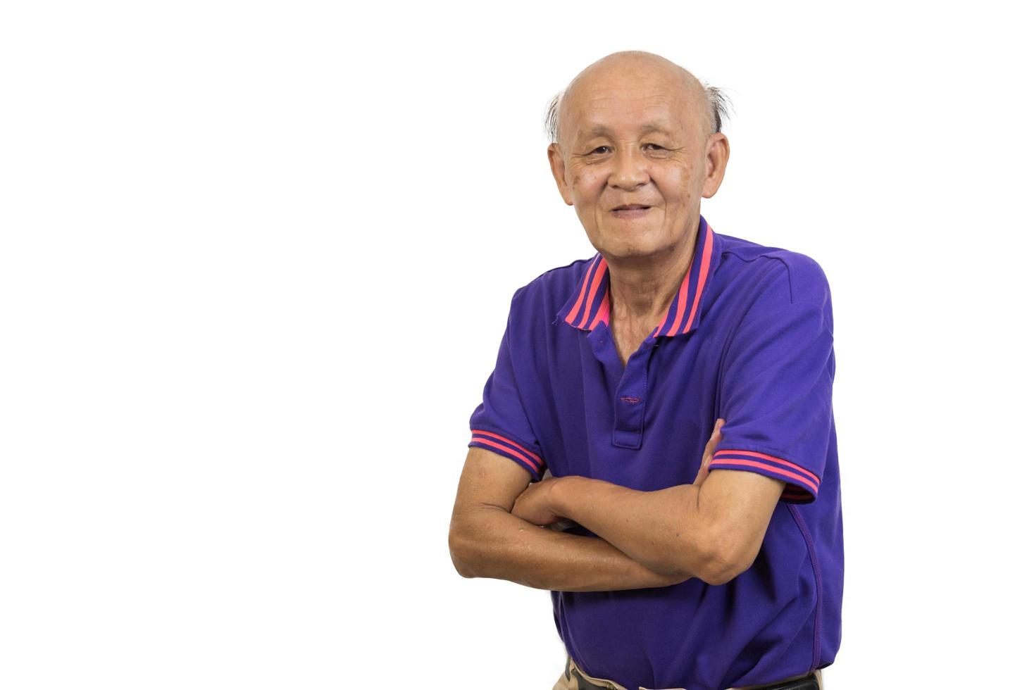 Asian elderly man standing with his arms crossed white background. photo