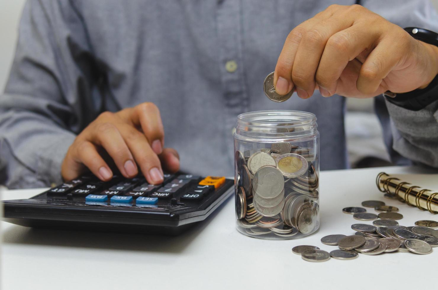 male businessman use calculator money coin financial tax and planning investments marketing economy income and retirement saving. photo