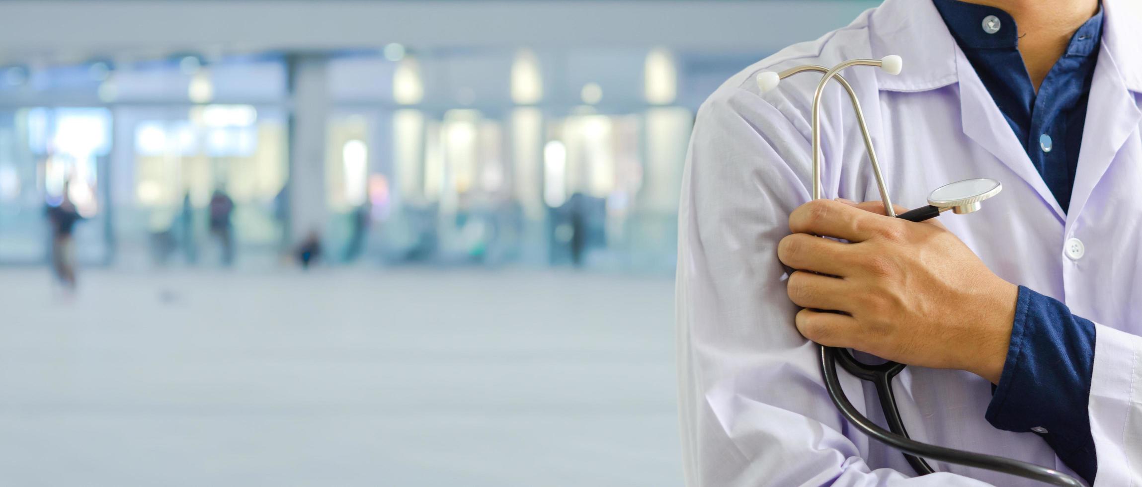 médico con estetoscopio de pie y diagnóstico en el hospital. atención médica y concepto de panorama de fondo de seguro médico o de salud. foto