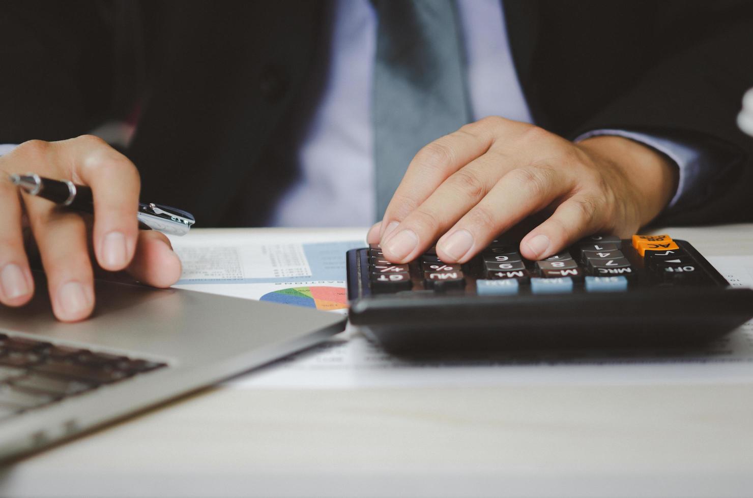 businessman holding calculators and business documents charts statistical data investment analysis and tax accounting. photo